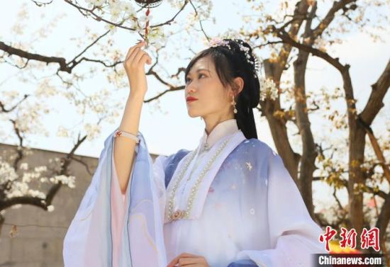 圖為蘭州青年身穿漢服在百年梨園賞景?！「哒?攝