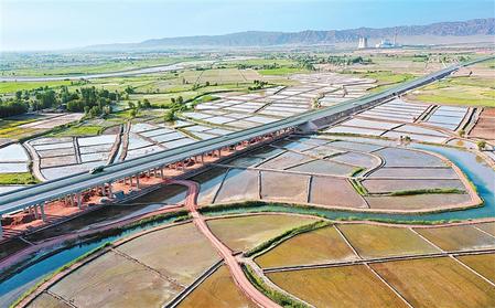 甘蒙高速公路與甘州區(qū)烏江鎮(zhèn)元豐村的稻田和蔬菜基地構(gòu)成一幅美麗的畫(huà)卷