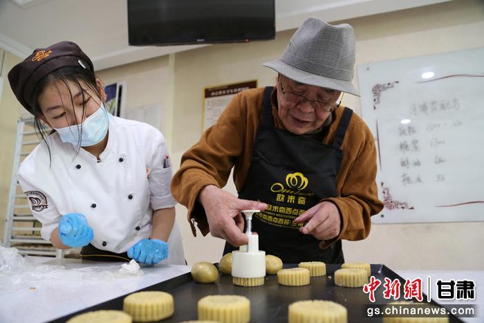 當(dāng)日，受邀參加活動(dòng)的臺(tái)胞臺(tái)屬代表、兩岸婚姻及子女、在甘臺(tái)商代表等歡聚一堂。圖為77歲的在甘臺(tái)胞潘天鑒制作月餅。九美旦增 攝