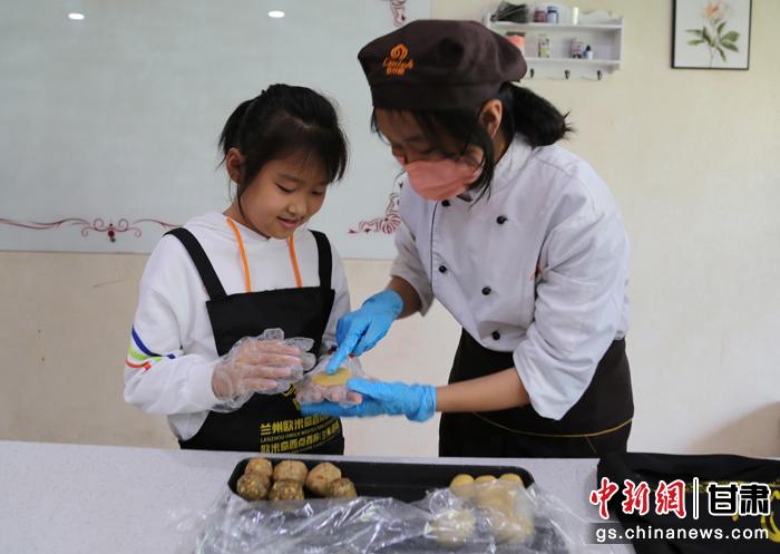 圖為在甘臺(tái)胞小朋友在工作人員指導(dǎo)下制作月餅。九美旦增 攝